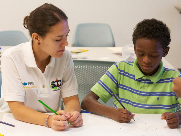 A student working with a child at Drexel's STEM Camp